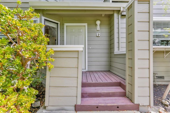 Entrance area of a house with brown steps leading to a white door.