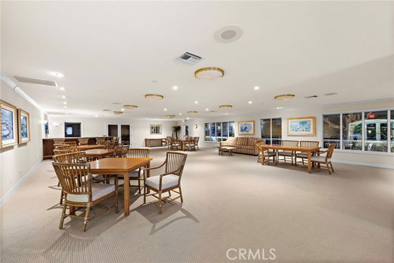 Spacious indoor clubhouse area with tables and chairs.