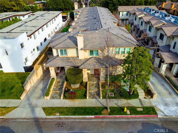 Elevated view of a two-story building with a tiled roof and a front entrance.