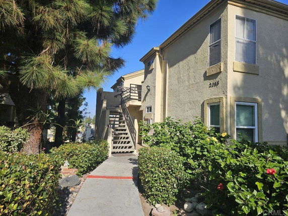 Front view of a two-story building with external staircase.