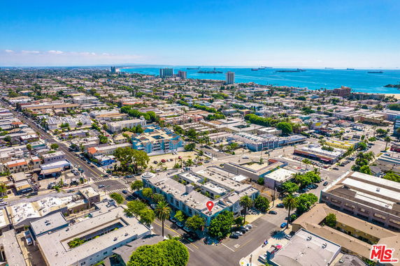 Aerial panoramic view of a coastal city with visible buildings and coastline.