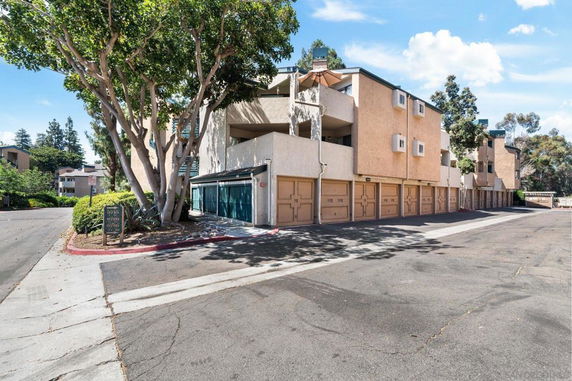 Front view of a multi-story apartment building with attached garages.