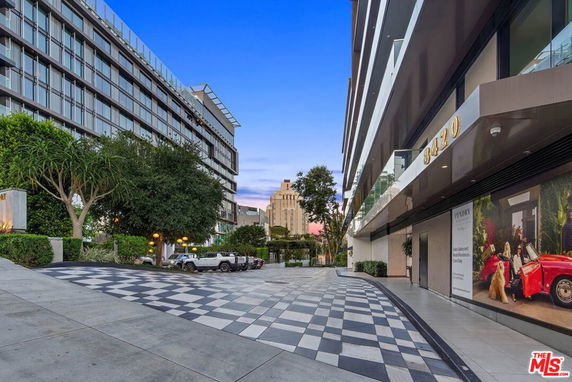 View of modern multi-story buildings with glass facades and a checkered pathway.