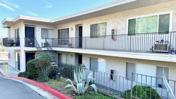 Front view of a two-story apartment building with balconies.