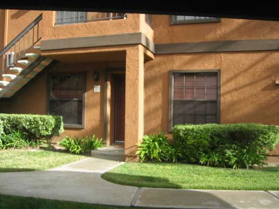 Front view of a two-story house with brown stucco exterior and a staircase.
