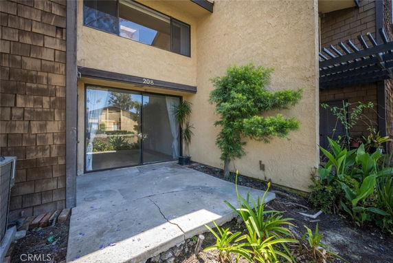 Front view of a building entrance with a sliding glass door and numbered awning.