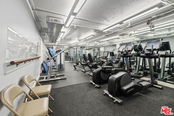 Indoor gym area with exercise equipment and mirrors.