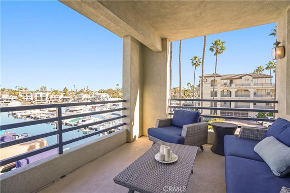 Balcony view overlooking a marina and apartment buildings.