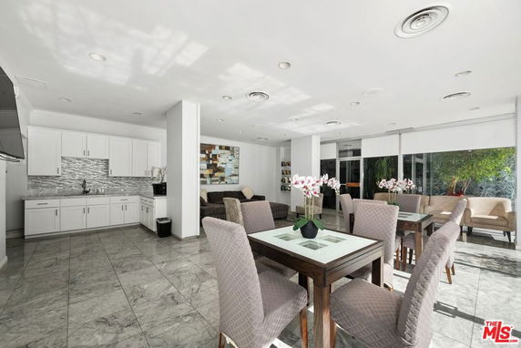 Interior view of a clubhouse with seating areas and a small kitchenette.