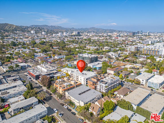 Aerial view of a residential and commercial area with multiple buildings and a marker indicating a specific location.
