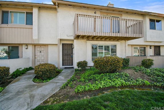 Front view of a two-story townhouse with a balcony.