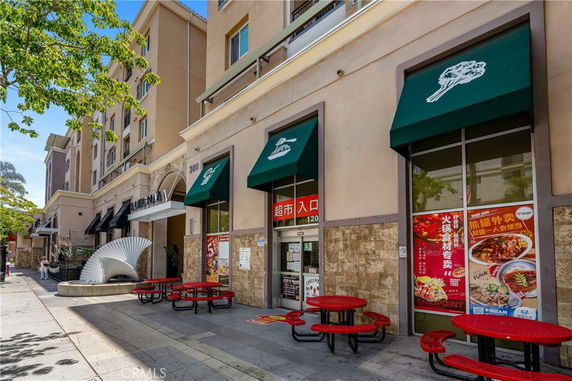 Front view of a commercial building with awnings and outdoor seating.