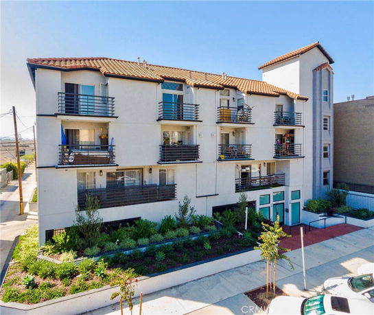 Front view of a multi-story apartment building with balconies.