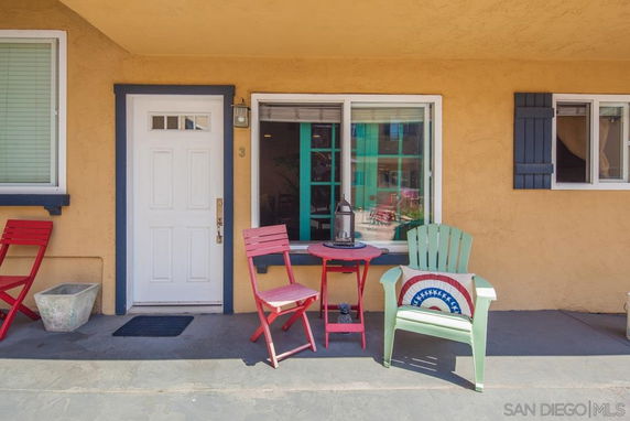 Front view of a house with a small outdoor seating area.