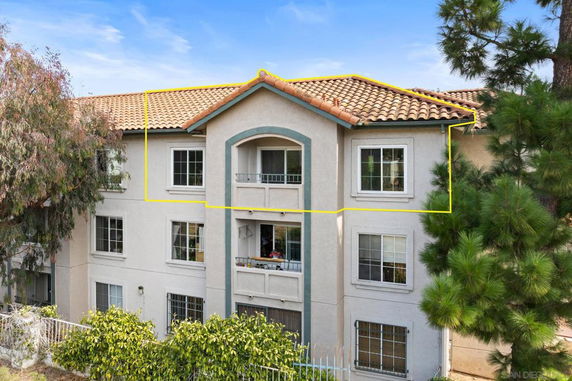 Front view of a two-story building with a tiled roof and balcony.