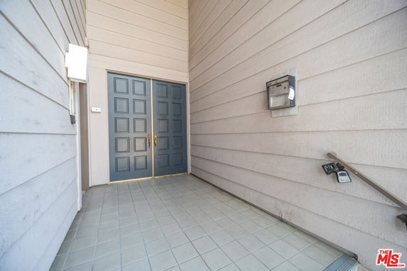 Entrance area with double doors and tiled flooring.