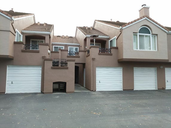 Front view of a multi-story building with garages and balconies.