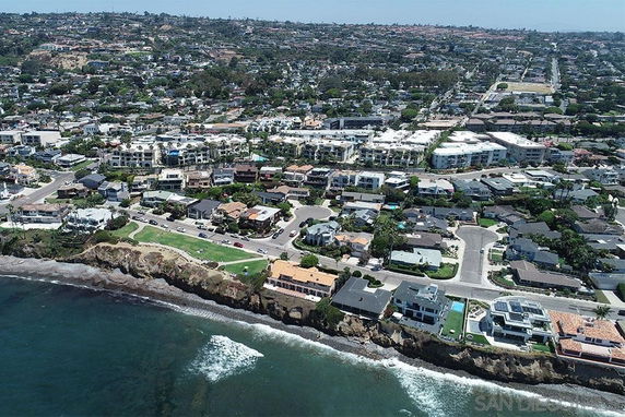 Panoramic view of coastal residential area with houses overlooking the ocean.