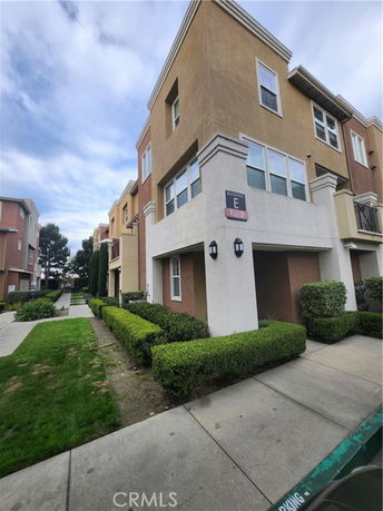 Front view of a multi-story residential building with beige and brown exterior.