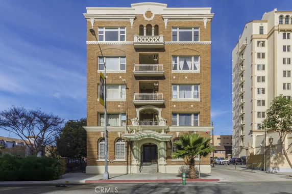 Front view of a multi-story brick building with balconies.