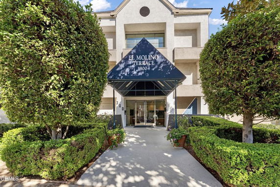 Front view of a multi-story building with an entryway and canopy.