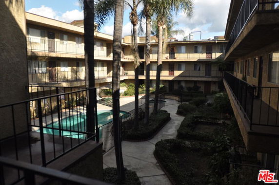Residential complex with a courtyard swimming pool and surrounding balconies.