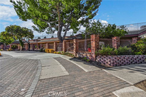 Front view of a house with a brick fence and walkway.