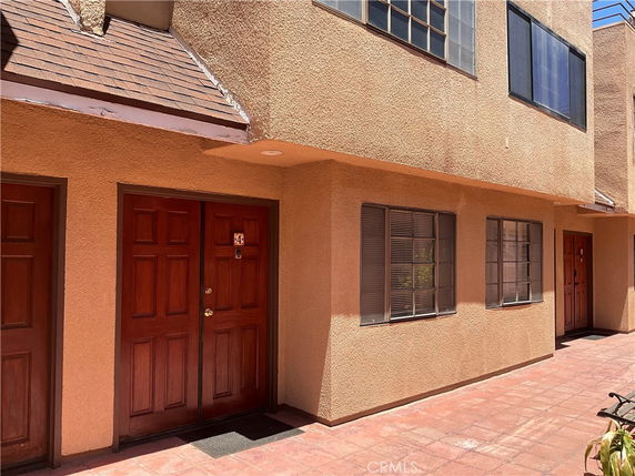 Front view of a multi-story building with wooden doors and windows.