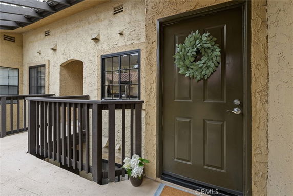 Exterior view of a building with a dark door and decorative wreath.