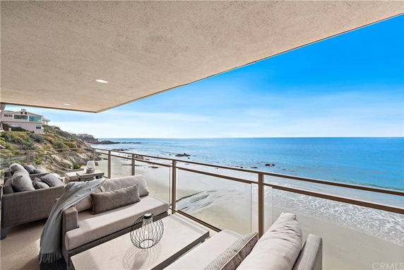 View from a balcony overlooking a beach and ocean.