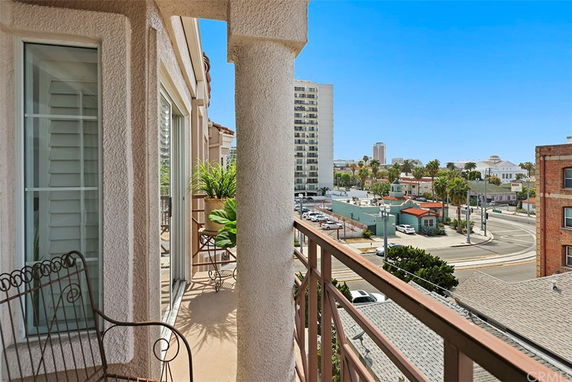 Panoramic view from a building balcony overlooking city streets and buildings.