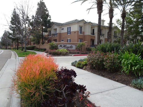 Front view of a multi-story residential building with landscaped surroundings.