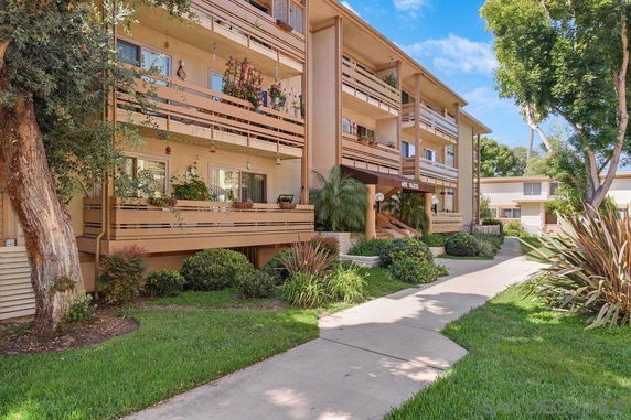 Front view of a three-story apartment building with balconies.