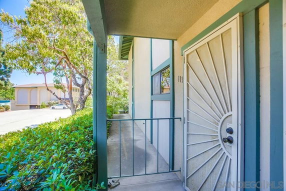 Entrance view of a house with a metal security door and covered porch.