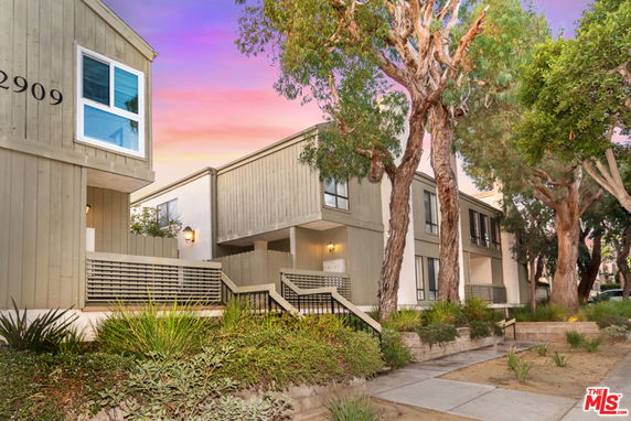 Front view of a multi-unit residential building with a modern design and large windows.