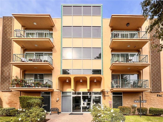 Front view of a multi-story apartment building with balconies.