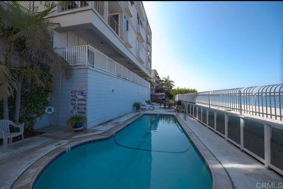 Outdoor swimming pool next to a multi-story building.