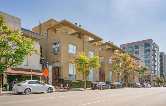 Front view of a multi-story building with large windows and a flat roof.