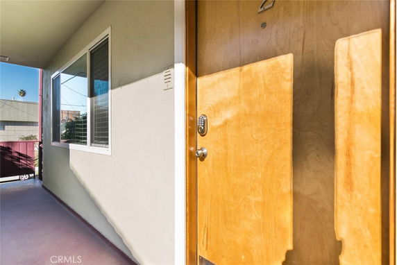 Front view of an apartment entrance with a wooden door and window.