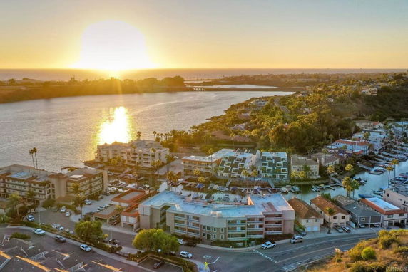 Panoramic view of a waterfront area with buildings and a sunset.
