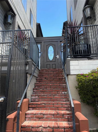 Front view of a house with brick stairs leading to an entrance door.