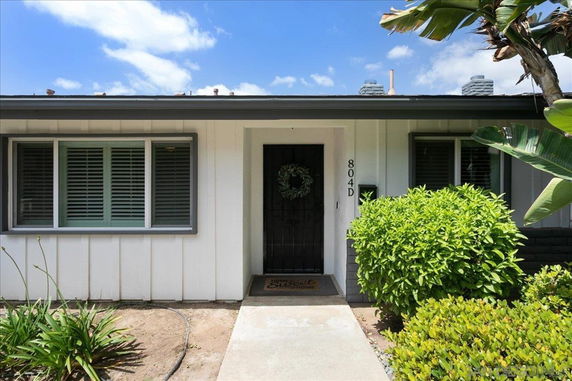 Front view of a single-story house with white siding and shuttered windows.