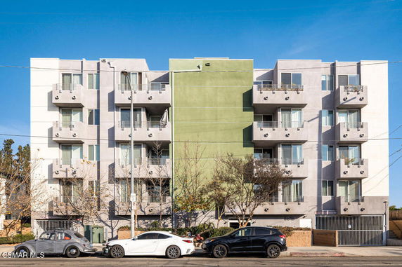 Front view of a multi-story apartment building with balconies.