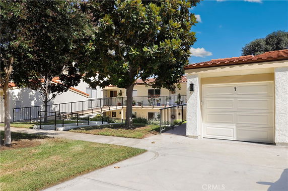 Front view of a house with a single garage and ramp entrance.