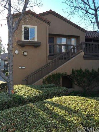 Front view of a two-story house with an external staircase.