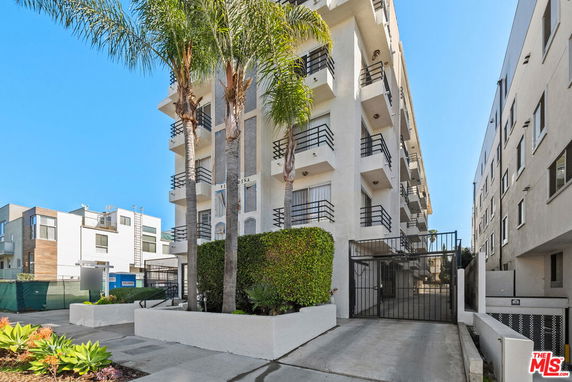 Front view of a multi-story apartment building with balconies.