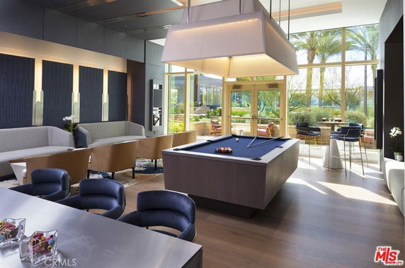 Interior view of a recreation area with a billiards table and seating.