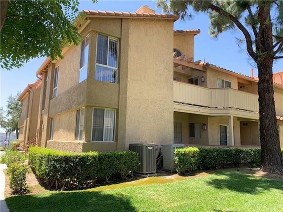 Front view of a multi-story building with beige exterior and a tiled roof.