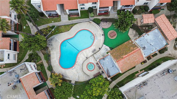 Aerial view of a residential area with a central outdoor swimming pool surrounded by buildings.