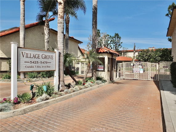Front view of gated condominium complex with a sign reading Village Grove.